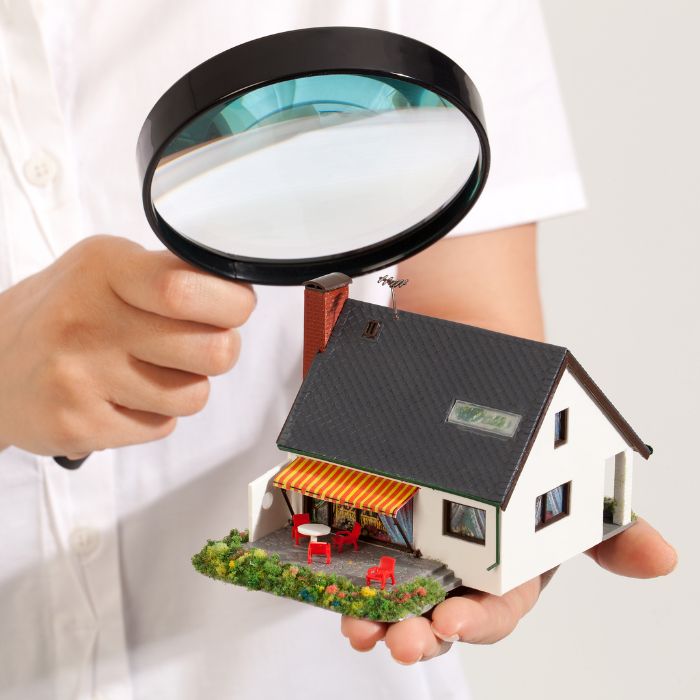 man holding magnifying glass to inspecto toy house center tx